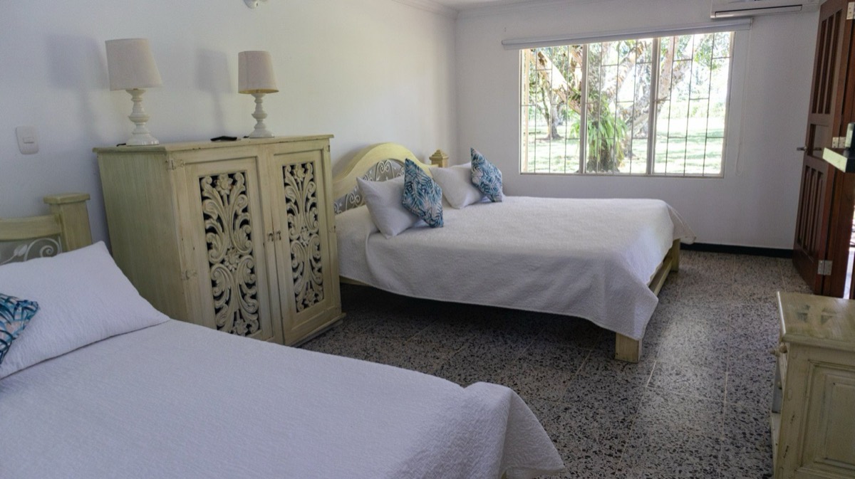 Habitación luminosa con varias camas en cabaña de Finca San Luis